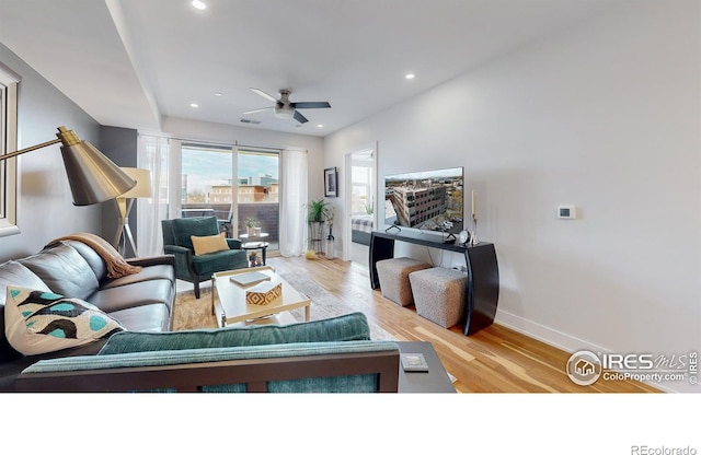 living room featuring ceiling fan and light hardwood / wood-style flooring