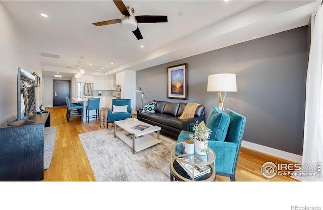 living room featuring ceiling fan and light wood-type flooring