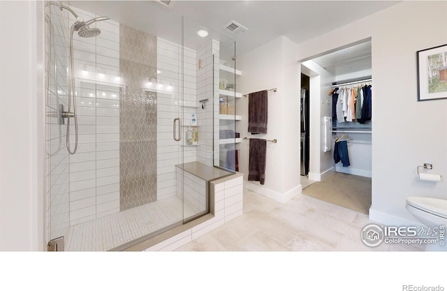 bathroom with tile patterned floors, toilet, and walk in shower