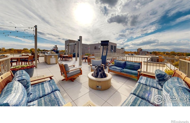 view of patio with an outdoor living space with a fire pit