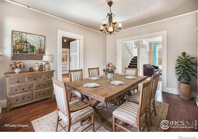 dining room with dark wood-type flooring and a chandelier