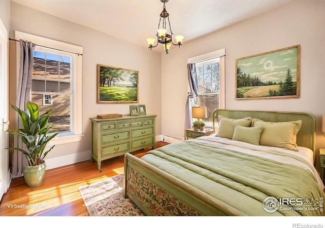 bedroom with a notable chandelier and light hardwood / wood-style flooring