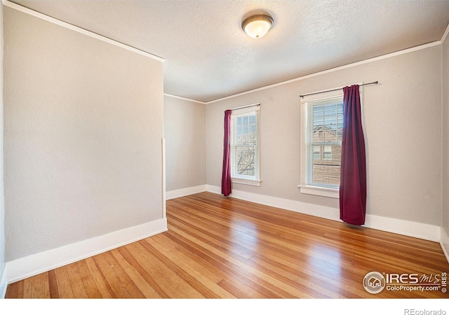 unfurnished room with ornamental molding, wood-type flooring, and a textured ceiling