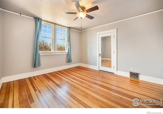 empty room with ceiling fan, ornamental molding, hardwood / wood-style floors, and a textured ceiling