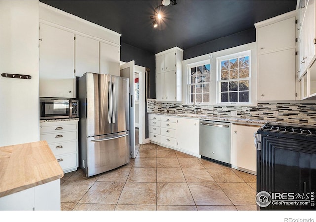 kitchen with white cabinetry, backsplash, and appliances with stainless steel finishes