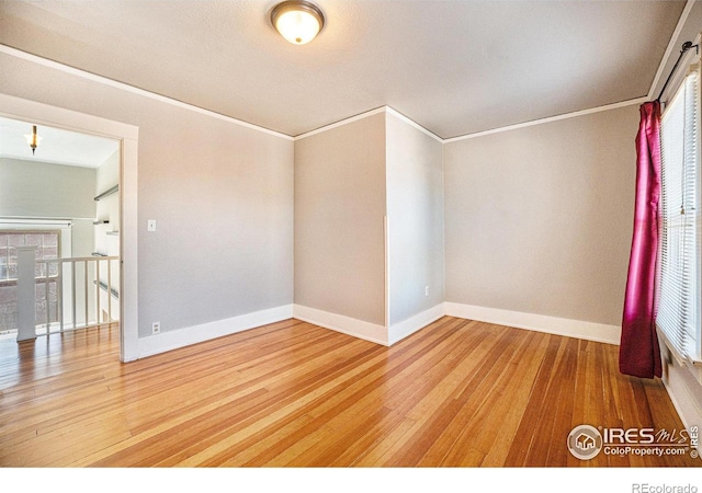 empty room featuring hardwood / wood-style floors and ornamental molding