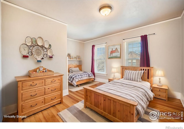 bedroom featuring ornamental molding and light hardwood / wood-style floors