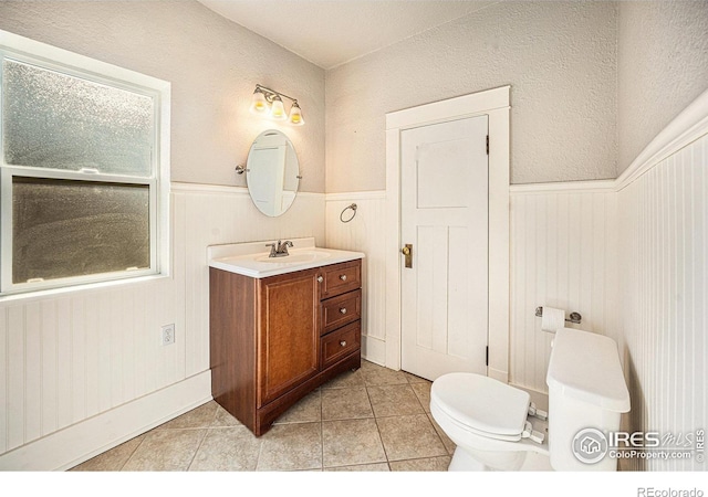 bathroom with tile patterned flooring, vanity, and toilet