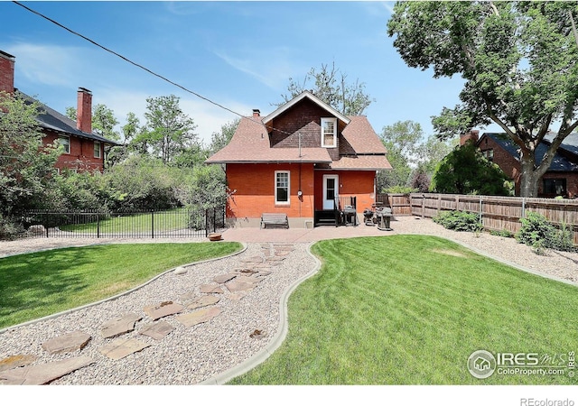 back of house with a yard and a patio