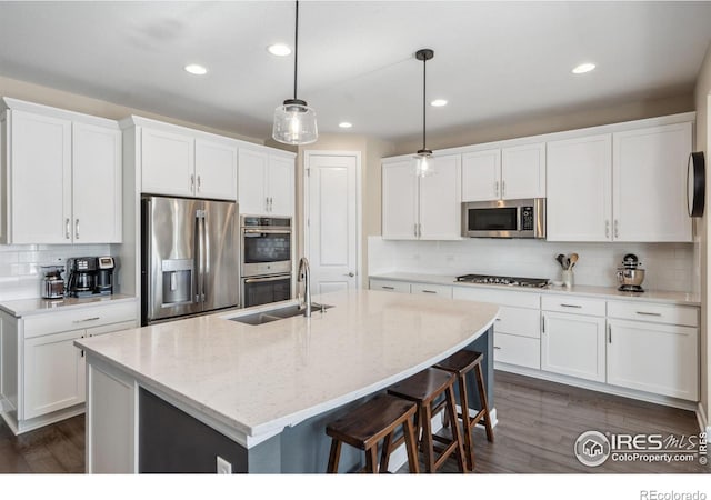 kitchen featuring pendant lighting, white cabinetry, appliances with stainless steel finishes, and sink