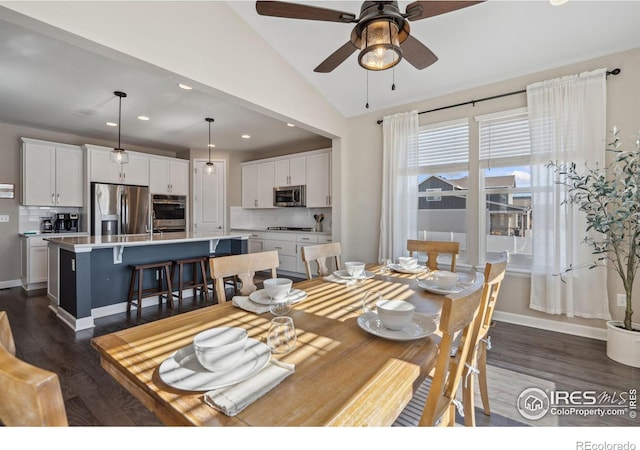 dining space featuring vaulted ceiling, ceiling fan, and dark hardwood / wood-style flooring