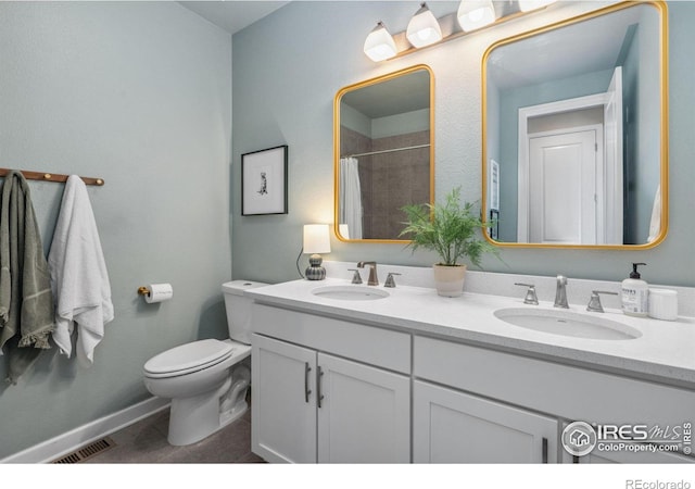 bathroom featuring vanity, tile patterned flooring, toilet, and walk in shower