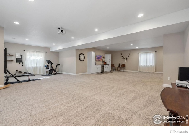 workout room featuring light carpet