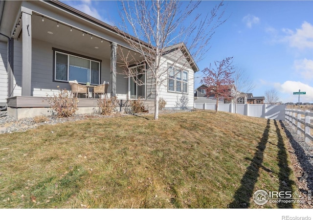 view of side of home with a yard