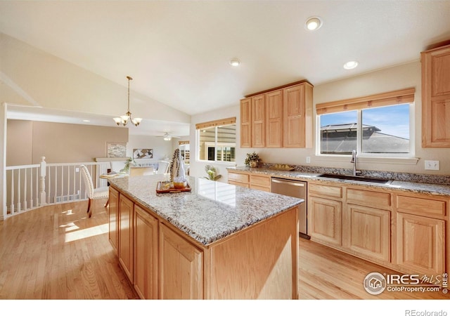 kitchen with decorative light fixtures, stainless steel dishwasher, vaulted ceiling, a kitchen island, and light wood-type flooring