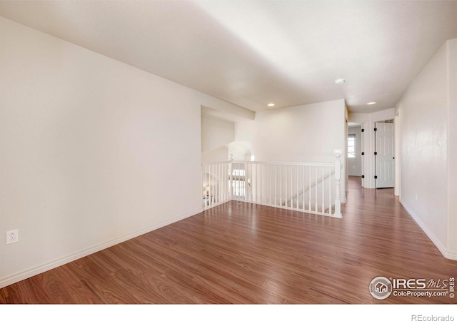 spare room featuring dark wood-style flooring and baseboards