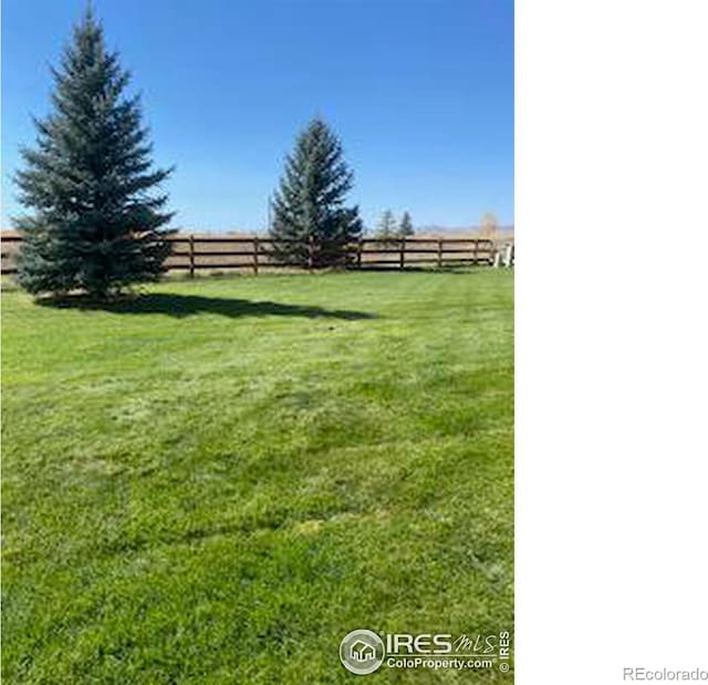 view of yard featuring fence and a rural view