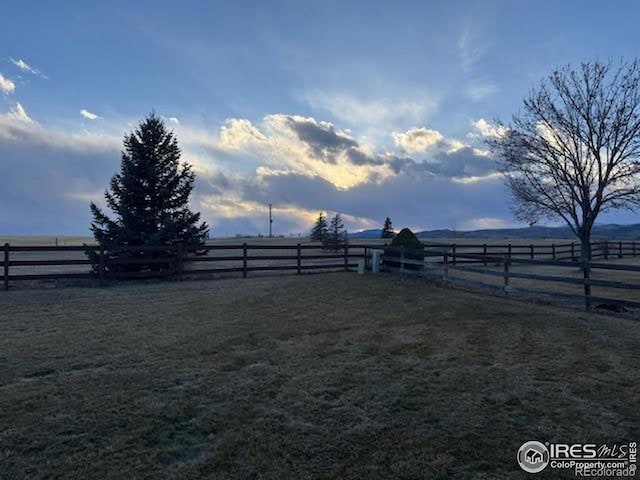 view of yard featuring fence and a rural view