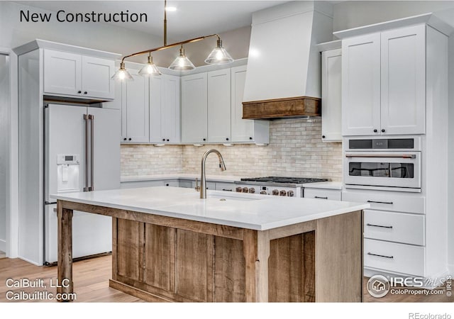 1233 Eliza Ave, Berthoud, CO 80513 - kitchen featuring white appliances, wall chimney exhaust hood, light countertops, tasteful backsplash, and light wood-style floors