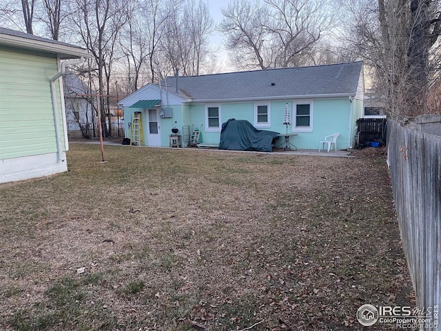 rear view of property featuring a patio and a lawn