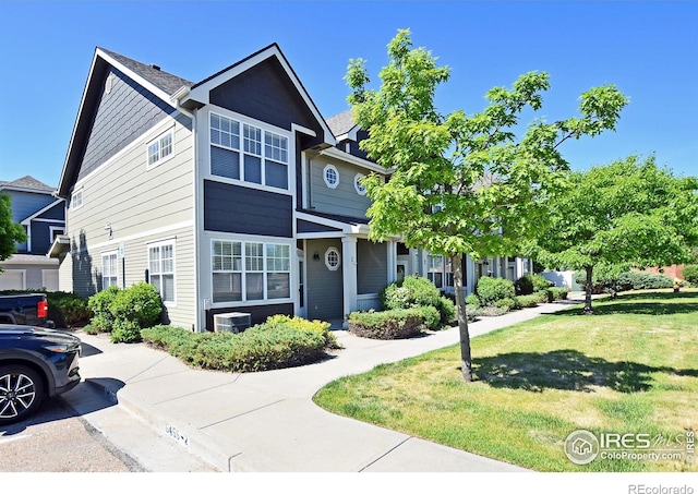 view of front of home with cooling unit and a front lawn