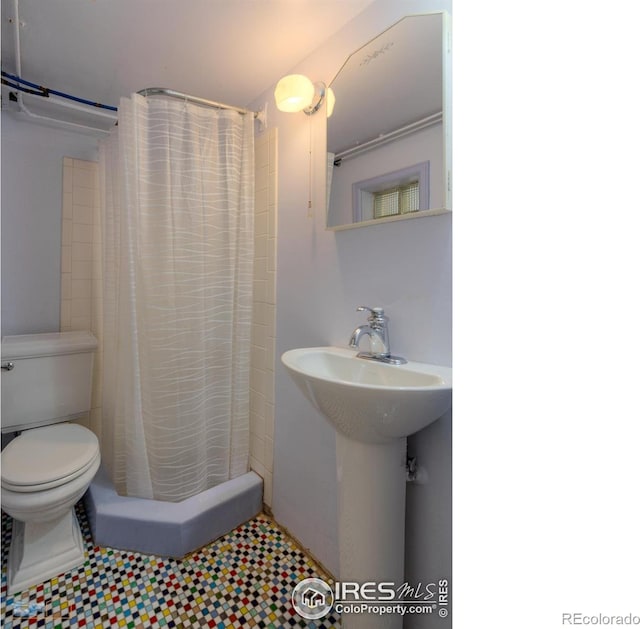 bathroom with toilet, tile patterned floors, a shower with shower curtain, and a sink