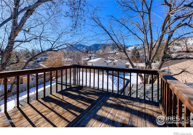 snow covered deck with a mountain view