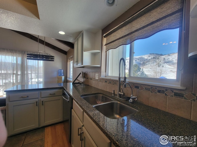 kitchen with sink, dark stone countertops, backsplash, lofted ceiling with beams, and a mountain view