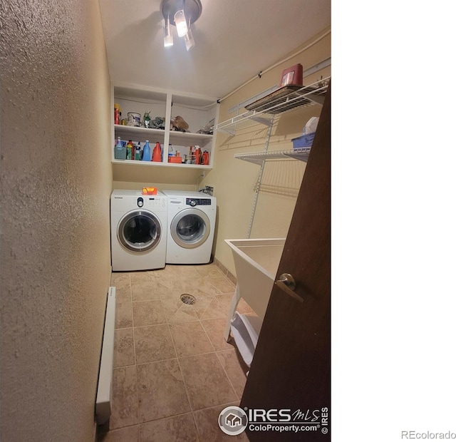 laundry room with sink, washing machine and dryer, and light tile patterned flooring