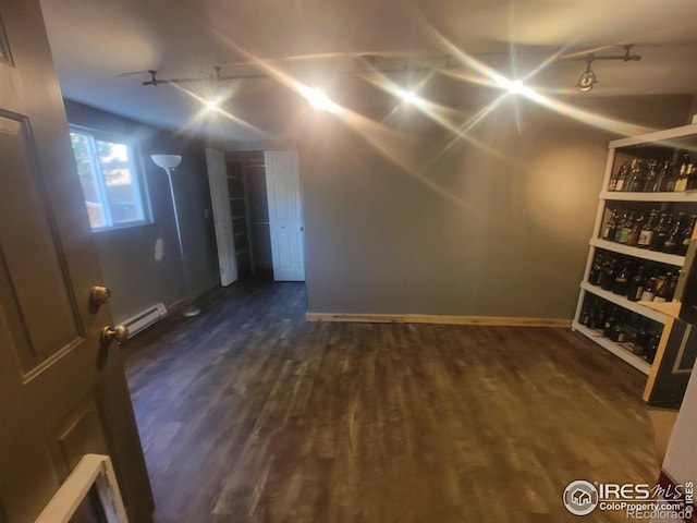 interior space featuring a baseboard radiator, dark hardwood / wood-style flooring, and rail lighting