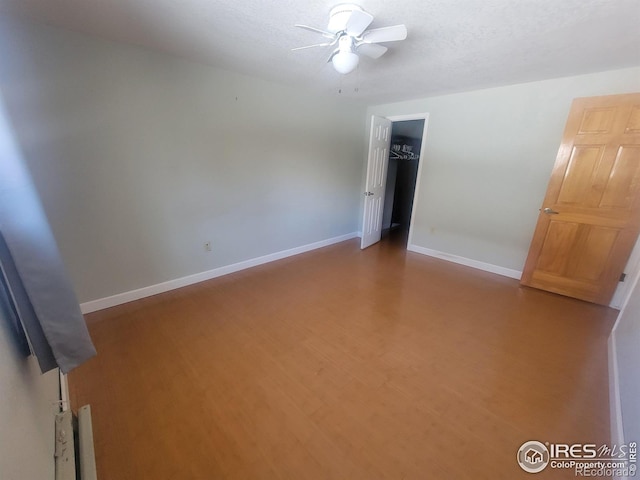 unfurnished room featuring a textured ceiling, wood-type flooring, and ceiling fan