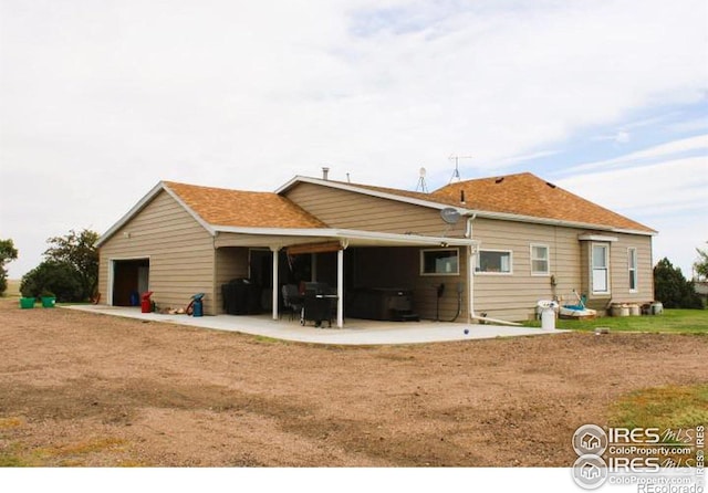 back of house featuring a garage and a patio