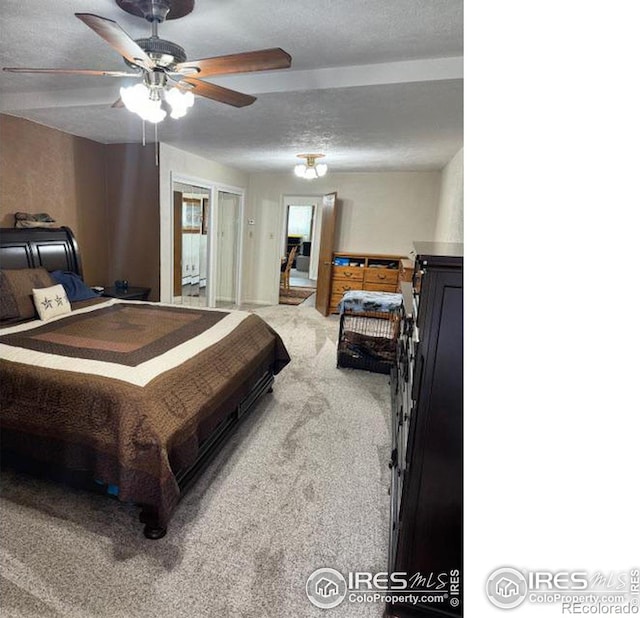 carpeted bedroom featuring ceiling fan and a textured ceiling