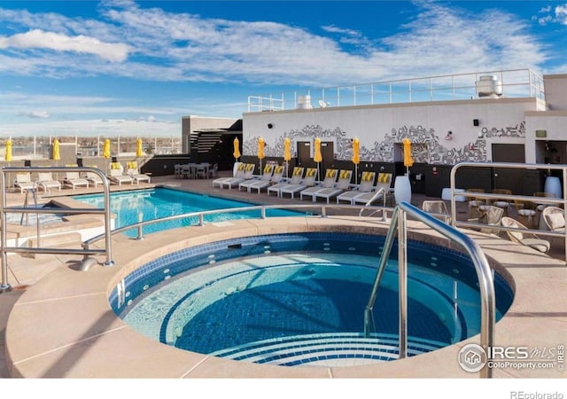 view of swimming pool featuring a community hot tub and a patio