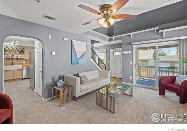 living room with light carpet, sink, a wealth of natural light, and ceiling fan