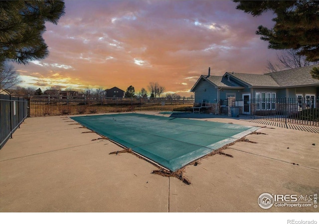 pool at dusk with a patio