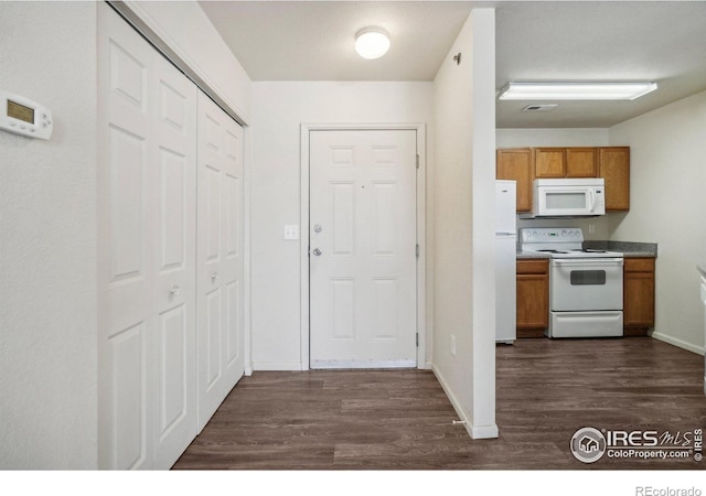 kitchen featuring white appliances and dark hardwood / wood-style flooring