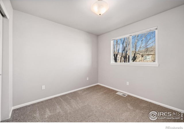 unfurnished bedroom with a closet, carpet flooring, visible vents, and baseboards