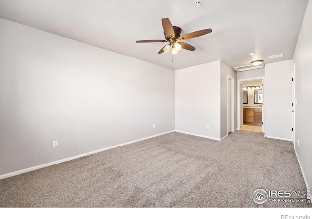 unfurnished bedroom with light carpet, attic access, visible vents, baseboards, and ensuite bath