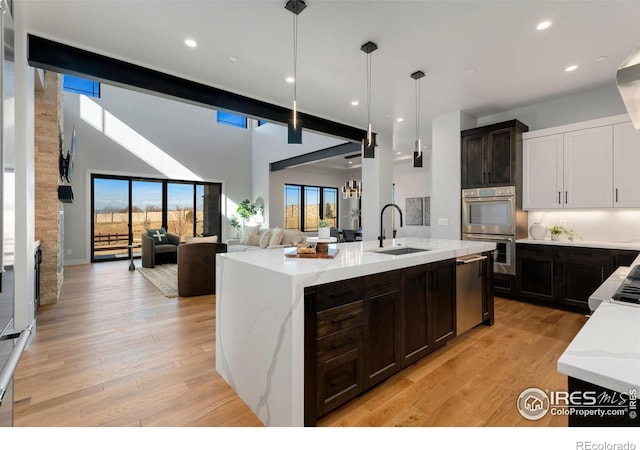 3650 Tall Grass Ct, Timnath, CO 80547 - kitchen with a sink, stainless steel appliances, light stone counters, light wood-type flooring, and recessed lighting