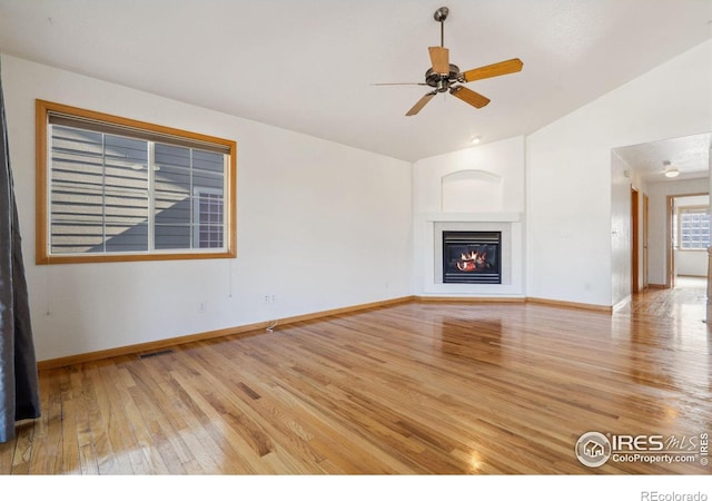 unfurnished living room with ceiling fan, vaulted ceiling, and wood-type flooring