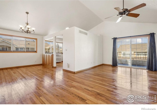 unfurnished living room featuring vaulted ceiling, ceiling fan with notable chandelier, and hardwood / wood-style floors