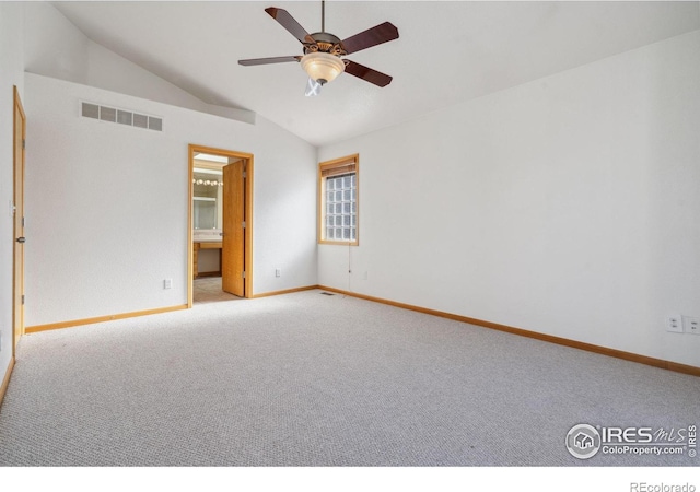 carpeted empty room featuring vaulted ceiling and ceiling fan