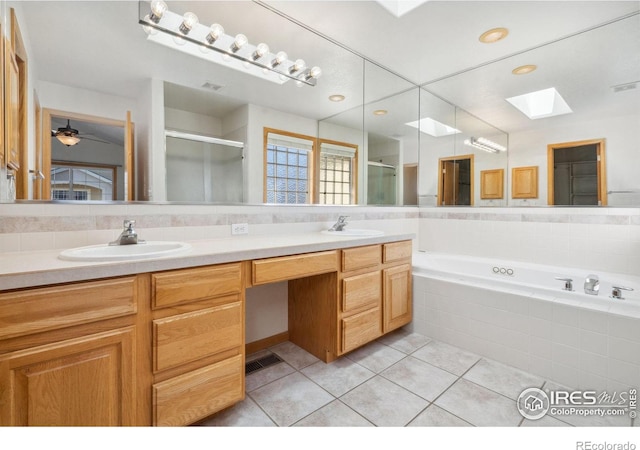 bathroom with vanity, separate shower and tub, tile patterned floors, and a skylight