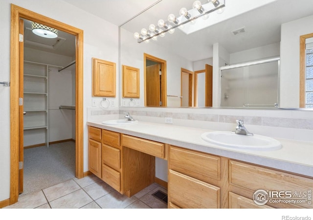 bathroom with vanity, a shower with shower door, and tile patterned floors