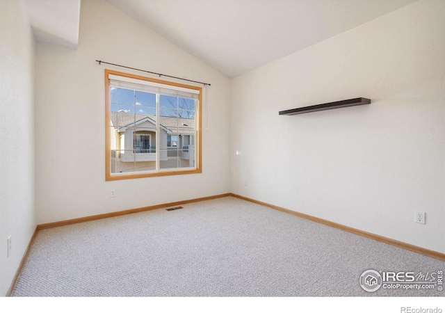 empty room featuring vaulted ceiling and carpet floors