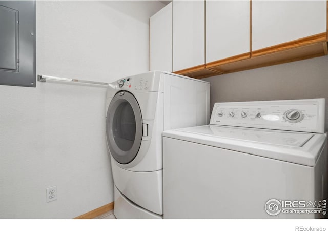 clothes washing area featuring washer and dryer, electric panel, and cabinets