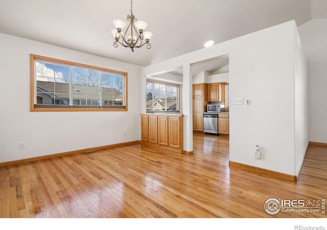 unfurnished dining area featuring lofted ceiling, a chandelier, and light wood-type flooring