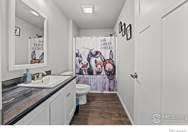 bathroom featuring vanity, hardwood / wood-style floors, a shower with shower curtain, and toilet