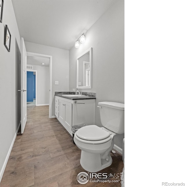 bathroom featuring hardwood / wood-style flooring, vanity, and toilet